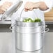 A person using a Vollrath pasta cooker to steam broccoli.