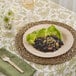 A Bambu Veneerware disposable bamboo plate with meat and vegetables on a table.