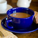 A blue Tuxton cappuccino cup of coffee on a saucer.