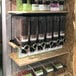 A shelf with different types of food containers holding coffee beans.