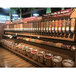 A row of Rosseto dry food dispensers on a shelf in a store.