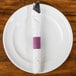 a fork and knife wrapped in a napkin on a plate