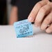 A person holding a blue 50/50 marquee raffle ticket.