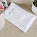 A stack of Oxford white hand towels on a counter.