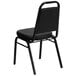 A Flash Furniture black vinyl banquet chair with black metal legs.