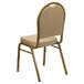 A beige banquet chair with a cushion and gold frame.