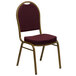 A red banquet chair with a gold frame and burgundy patterned cushion.