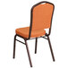 An orange Flash Furniture banquet chair with a copper metal frame.