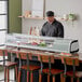 An Avantco refrigerated sushi display case on a countertop with food displayed inside.