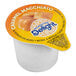 A close-up of a white package of International Delight Caramel Macchiato Single Serve Non-Dairy Creamer.