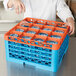 A person putting glasses in a blue and orange Carlisle glass rack.