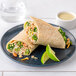 A plate with two Rich's gluten-free tortilla wraps and lime wedges on a white table.