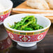 A close up of a bowl of green rice with chopsticks.