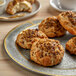 A plate with four biscuits and a cup of coffee on a table with a 35 lb. bag of Super Soaked Ancient Grains.