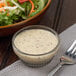 A bowl of salad with Ken's Foods Poppyseed Dressing and a fork.