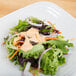 A plate with a salad including lettuce, carrots, and onions, with Ken's Foods Deluxe Thousand Island Dressing.