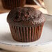 A Bake'n Joy double chocolate muffin on a white plate.