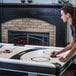 A woman playing air hockey on an Atomic air hockey table.