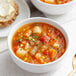 A bowl of Spring Glen Hearty Vegetable Soup with bread on a table.