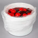 A white container of red pickled eggs.