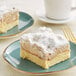 A piece of David's Cookies butter crumb cake on a plate with a cup of coffee.