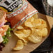 A tray with a sandwich and a bag of Route 11 Lightly Salted Potato Chips on a table in a deli.