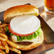 A burger and fries on a plate with a bun.