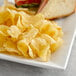 A plate with a sandwich and Route 11 Dill Pickle Potato Chips.