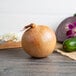 A 10 lb. Spanish onion on a table with other vegetables.