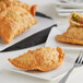 A plate with two Goya empanadas and a fork on a table.