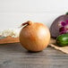 A Jumbo Sweet Onion on a table with other vegetables.