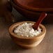 A wooden bowl of King Arthur Organic Bread Flour with a wooden spoon inside.