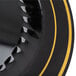 A close up of a Fineline black plastic plate with gold bands.