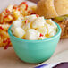 A bowl of Spring Glen Fresh Foods Dutch Potato Salad on a table next to a sandwich.