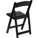 A black Flash Furniture plastic folding chair with a black padded seat.