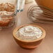 A bowl of cake flour next to a bowl of muffins.