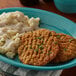 A plate of Advance Pierre Country Fried Steak with mashed potatoes and gravy on a table.