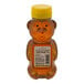 A 12-ounce plastic bear-shaped bottle of Sweet Harvest extra light amber honey with a yellow cap.