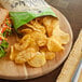 A sandwich and Miss Vickie's Jalapeno Kettle Potato Chips on a wooden board.