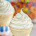 A close-up of a white ice cream cone with white soft serve inside.