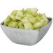 A Vollrath fluted metal bowl filled with diced melon.