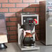 A Bloomfield Koffee King automatic coffee brewer on a counter with a brown pitcher.