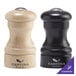 A black pepper shaker and a wooden salt shaker on a counter.