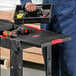 A man holding a Rubbermaid small utility cart with a tool box.