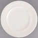 An ivory china plate with an embossed pattern on the rim.
