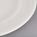 An ivory china plate with an embossed rim.