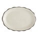 An ivory stoneware oval platter with a scalloped edge and black border.