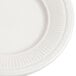 A close-up of an ivory (American white) rim china bread and butter plate with an embossed design.