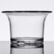 A clear plastic oyster cup with a rim on a table.