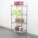 A four shelf metal rack with boxes on it.